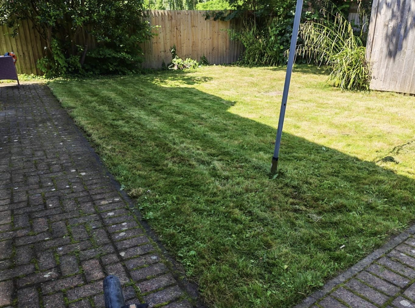 A domestic lawn cut and edged back to the brick path
